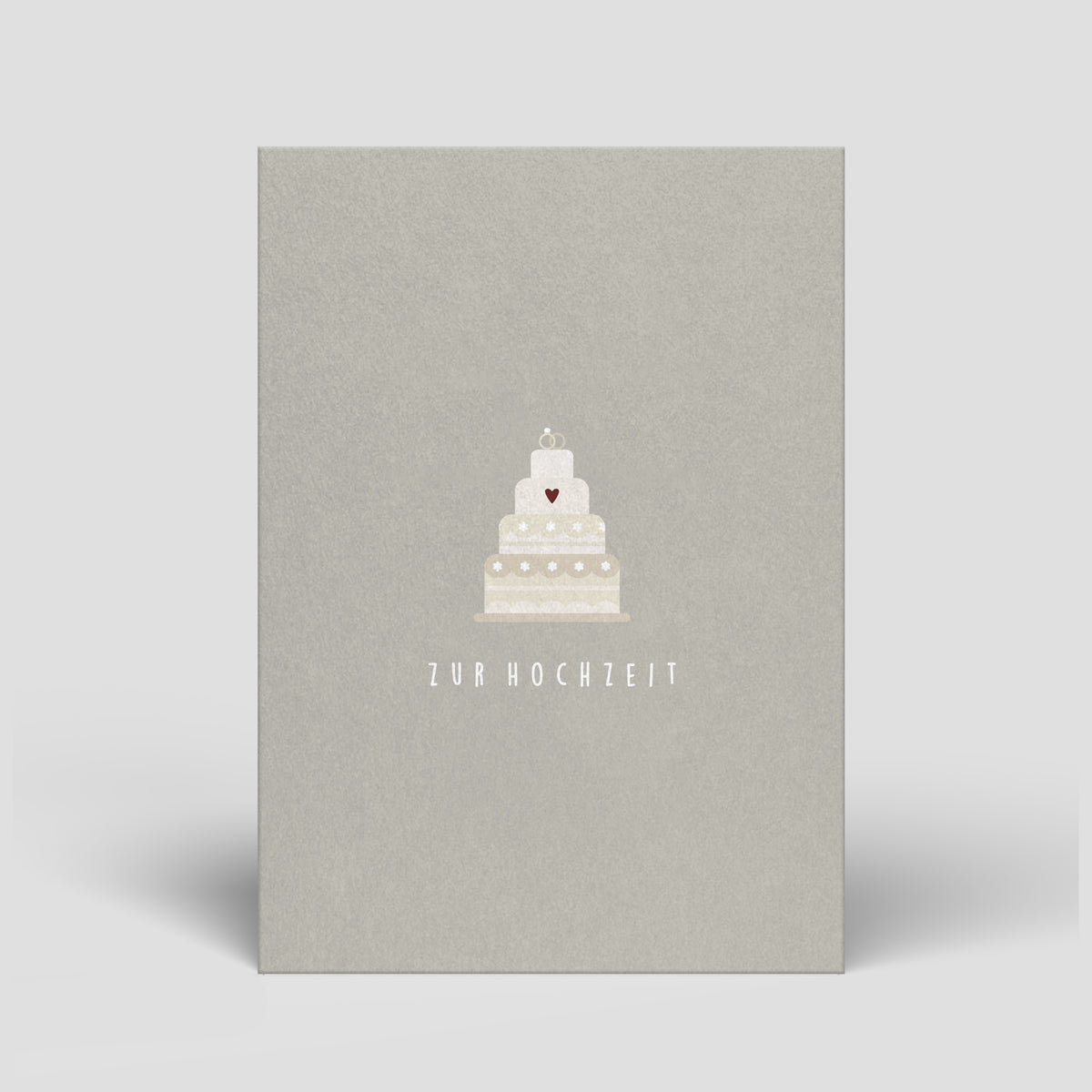 Graue Hochzeitskarte mit weißer Hochzeitstorte mit Herz und Schriftzug „zur Hochzeit“