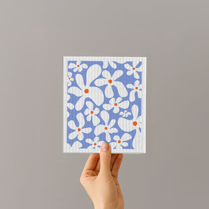 Schwammtuch aus Naturfaser mit blauem Blumenmuster, in Hand gehalten