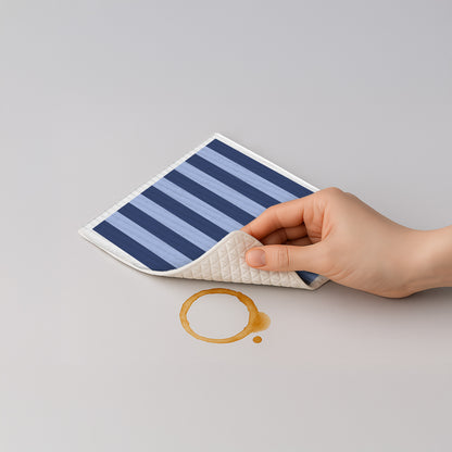 Blau gestreiftes Schwammtuch, gefaltet, von Hand zwischen Fingern gehalten