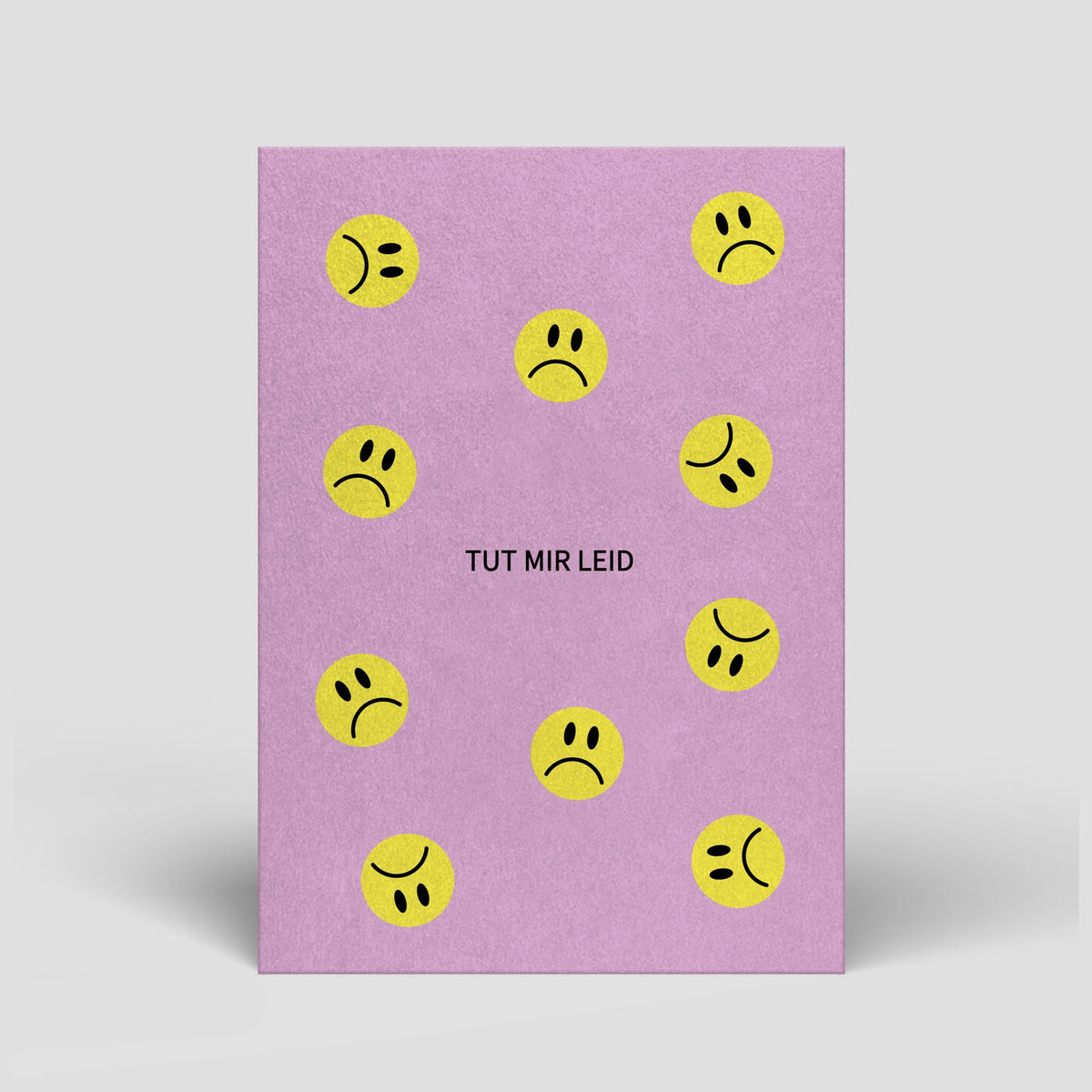 Lila Postkarte mit gelben Smiley-Gesichtern und Text „Tut mir leid“