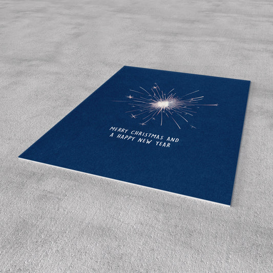 Blaue Neujahrs-Postkarte schräg, mit Knallstern und „Merry Christmas and a Happy New Year“