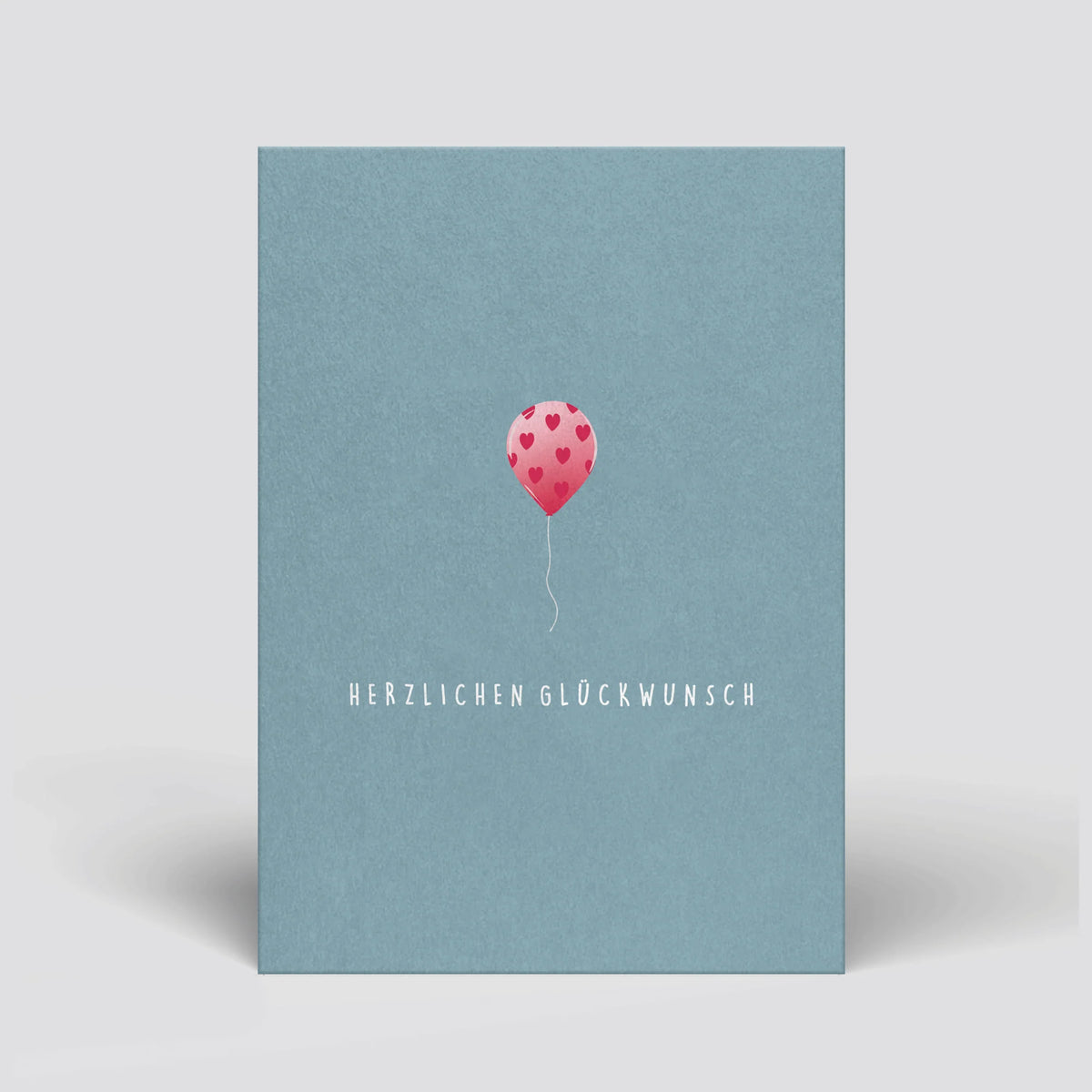 Geburtstags-Postkarte mit blauem Umschlag, rosa Herz-Luftballon und „Herzlichen Glückwunsch“