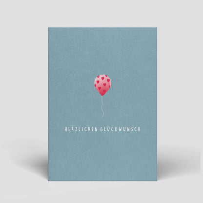 Geburtstags-Postkarte mit blauem Umschlag, rosa Herz-Luftballon und „Herzlichen Glückwunsch“