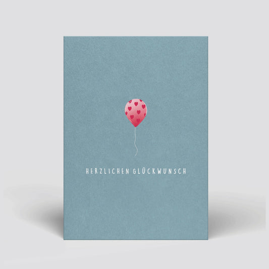 Geburtstags-Postkarte mit blauem Umschlag, rosa Herz-Luftballon und „Herzlichen Glückwunsch“